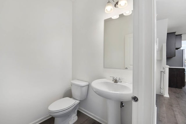 bathroom with hardwood / wood-style floors and toilet