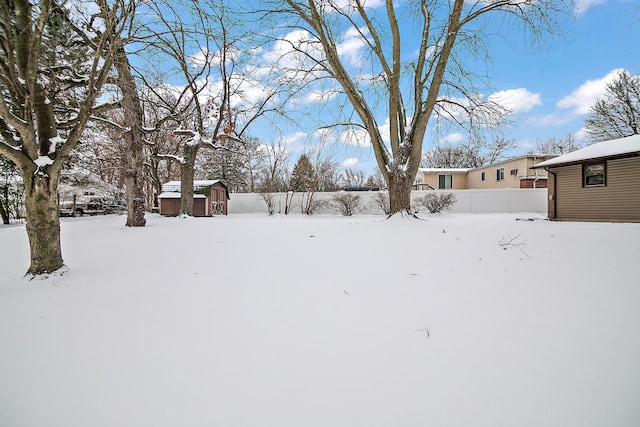 yard layered in snow featuring a storage shed