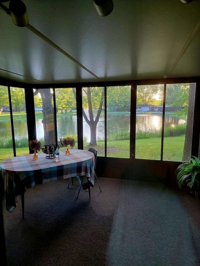 sunroom / solarium featuring a water view