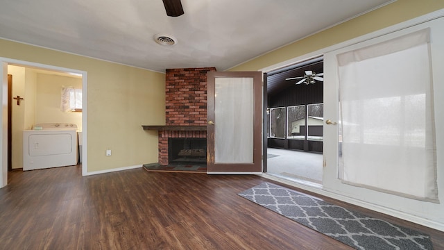 unfurnished living room with dark hardwood / wood-style floors, ceiling fan, washer / clothes dryer, and a brick fireplace