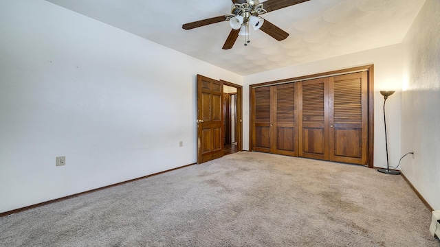 unfurnished bedroom with ceiling fan, a closet, and light carpet