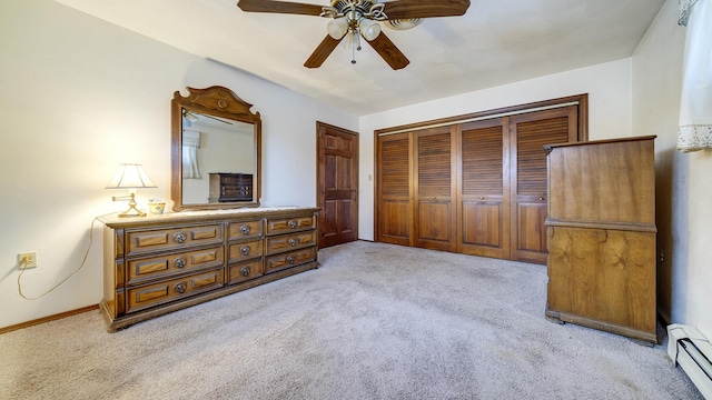 carpeted bedroom featuring a closet, a baseboard heating unit, and ceiling fan