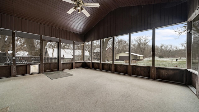 unfurnished sunroom featuring ceiling fan, a healthy amount of sunlight, vaulted ceiling, and wooden ceiling