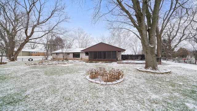 yard covered in snow with a sunroom