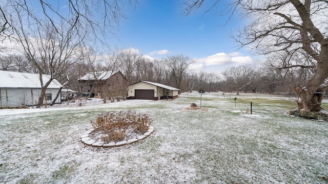 yard covered in snow featuring a garage and an outdoor structure