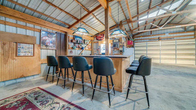 bar with wood walls, concrete flooring, and vaulted ceiling