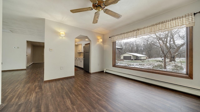 interior space featuring a wealth of natural light, dark hardwood / wood-style flooring, baseboard heating, and ceiling fan