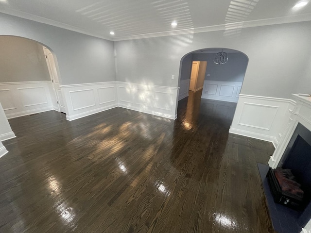 empty room featuring dark hardwood / wood-style floors, an inviting chandelier, and crown molding