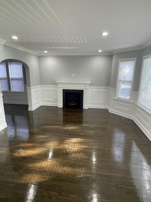 unfurnished living room featuring dark hardwood / wood-style flooring and ornamental molding