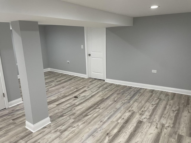 basement with light hardwood / wood-style flooring