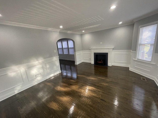 unfurnished living room featuring ornamental molding and dark wood-type flooring