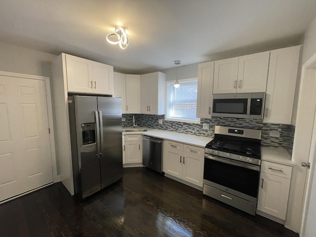 kitchen featuring pendant lighting, white cabinetry, stainless steel appliances, and tasteful backsplash