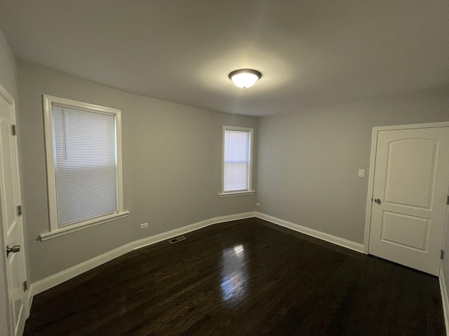 spare room with dark wood-type flooring