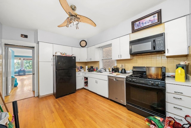 kitchen featuring black appliances, white cabinets, sink, light hardwood / wood-style flooring, and decorative backsplash