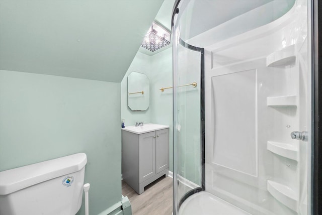 bathroom with wood-type flooring, lofted ceiling, toilet, vanity, and a shower with shower door