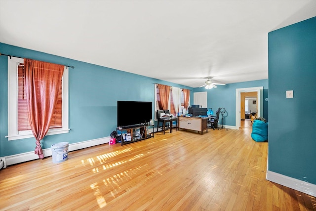 living room featuring light hardwood / wood-style floors, a baseboard radiator, and ceiling fan