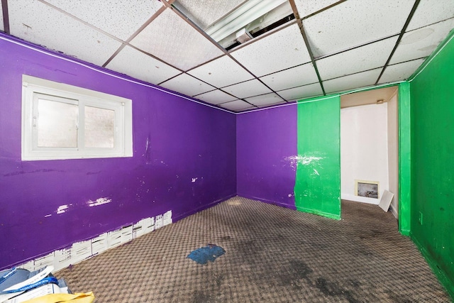 empty room with carpet flooring and a drop ceiling