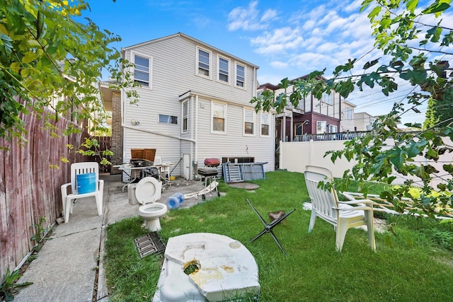 rear view of property featuring a yard and a patio