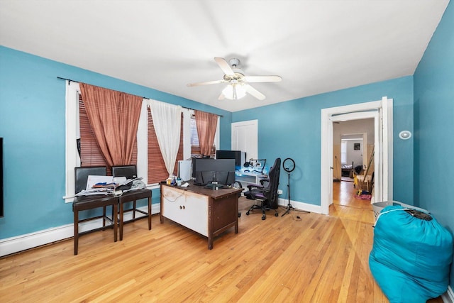 office with ceiling fan, a baseboard radiator, and light wood-type flooring