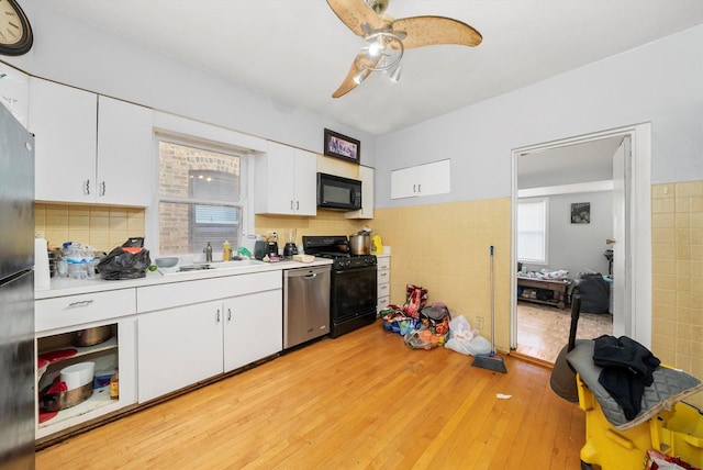 kitchen with sink, stainless steel dishwasher, light hardwood / wood-style floors, gas stove, and white cabinetry