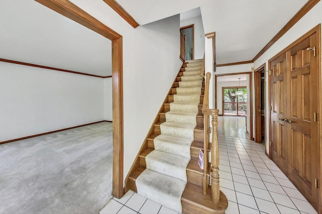 staircase with carpet floors and ornamental molding