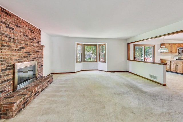 unfurnished living room featuring light carpet and a fireplace