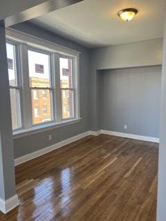 empty room with dark wood-type flooring