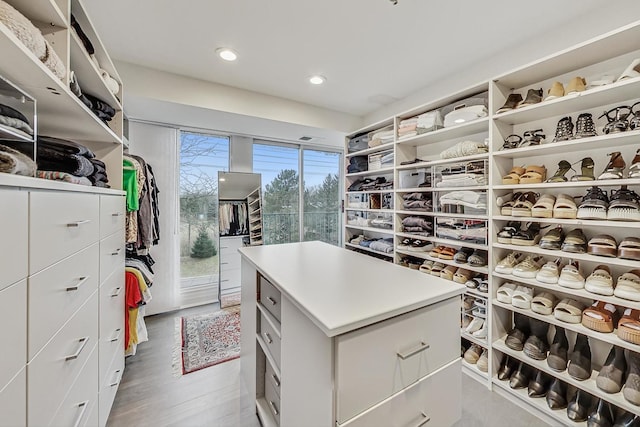 walk in closet with light hardwood / wood-style flooring