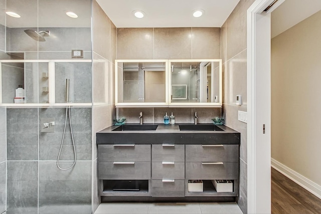 bathroom featuring hardwood / wood-style flooring, vanity, and a shower