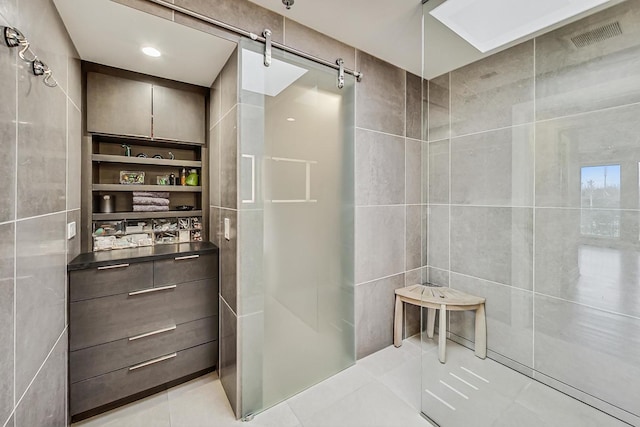 bathroom featuring walk in shower, tile patterned floors, and tile walls