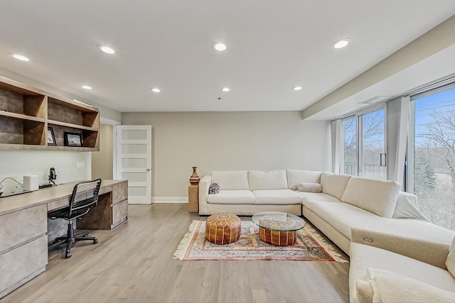 living room featuring built in desk and light hardwood / wood-style flooring