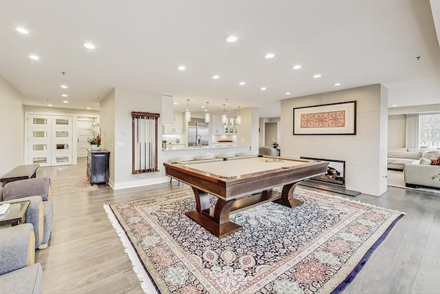 rec room with sink, pool table, and light wood-type flooring