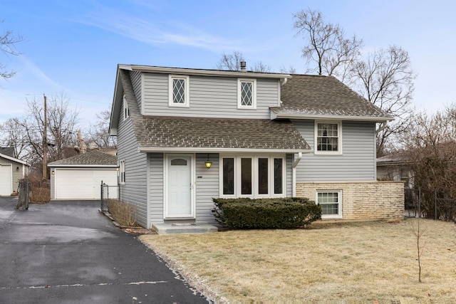 view of front of home with an outbuilding, a garage, and a front lawn