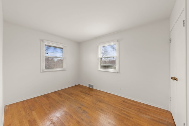 spare room featuring hardwood / wood-style floors and a wealth of natural light