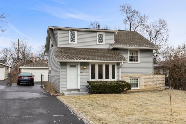 view of front of house featuring an outbuilding, a garage, and a front lawn