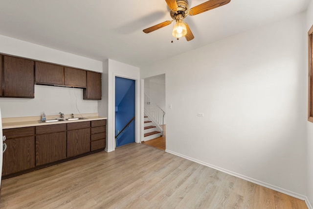 kitchen featuring dark brown cabinets, light hardwood / wood-style floors, sink, and ceiling fan