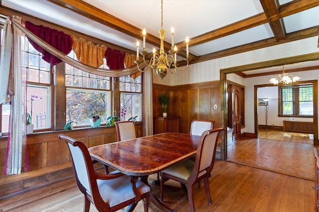 dining area with a healthy amount of sunlight, radiator, and a chandelier