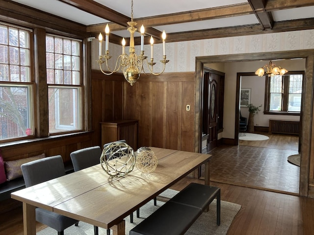 dining space featuring radiator, beam ceiling, coffered ceiling, dark hardwood / wood-style flooring, and an inviting chandelier