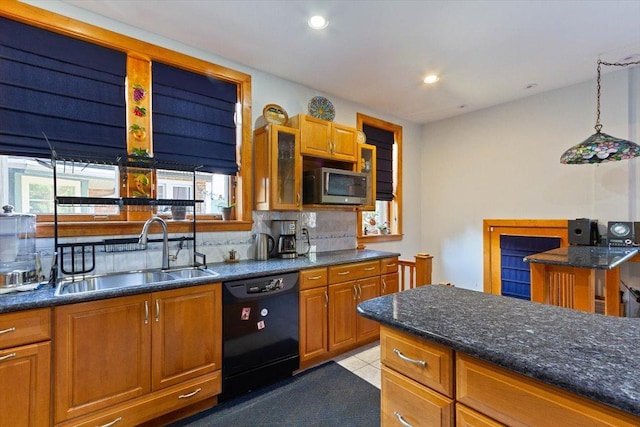 kitchen featuring decorative light fixtures, dishwasher, sink, backsplash, and dark stone counters