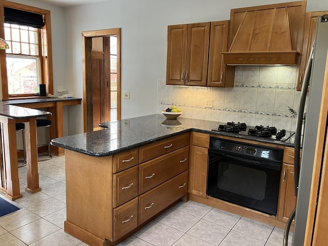 kitchen with kitchen peninsula, custom exhaust hood, black appliances, backsplash, and dark stone countertops