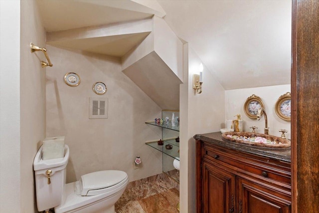 bathroom with lofted ceiling, vanity, and toilet