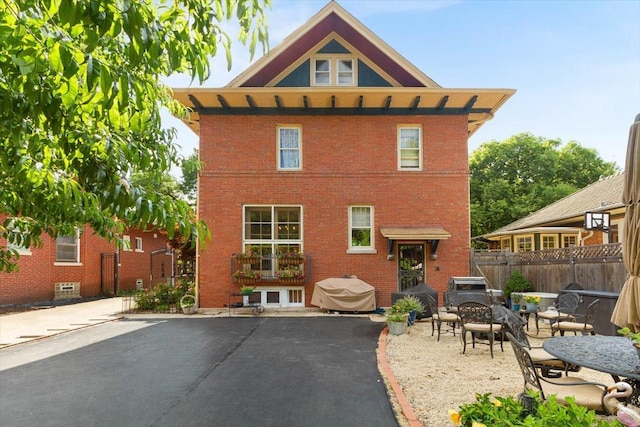 back of property with a patio and an outdoor fire pit