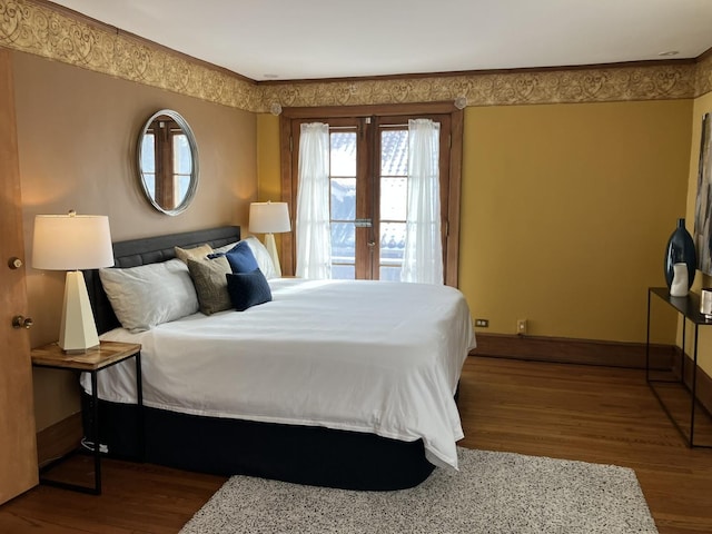 bedroom with french doors, hardwood / wood-style floors, and crown molding