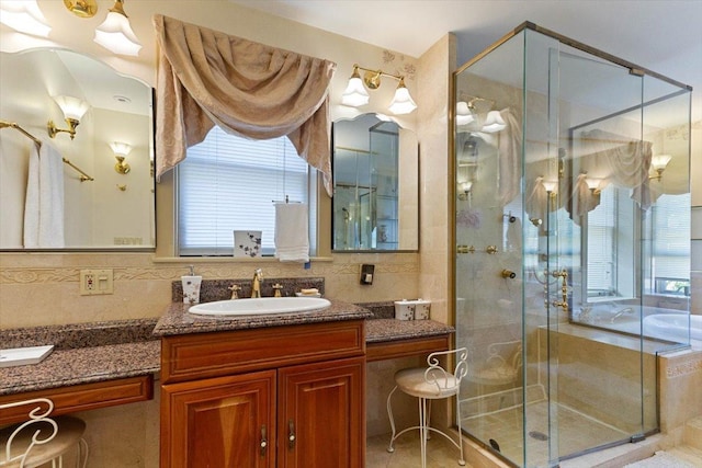 bathroom with vanity, backsplash, a shower with shower door, and plenty of natural light