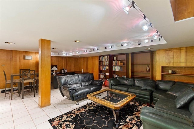 living room featuring wooden walls, built in features, and light tile patterned floors