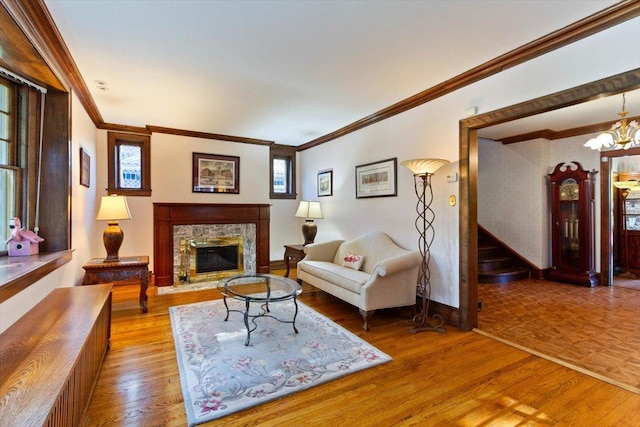 living room with an inviting chandelier, a high end fireplace, and crown molding