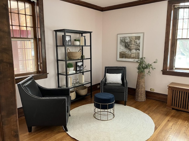 sitting room with radiator, ornamental molding, and hardwood / wood-style floors