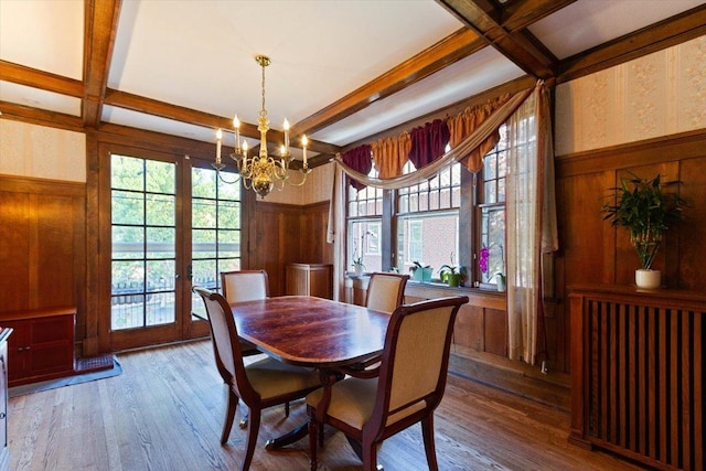 dining space featuring coffered ceiling, hardwood / wood-style floors, a notable chandelier, and beamed ceiling