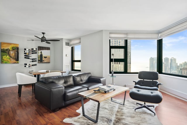 living room with dark wood-type flooring and ceiling fan