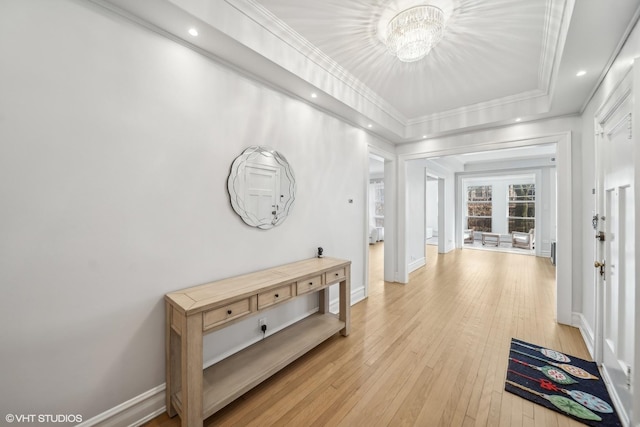 hall featuring light hardwood / wood-style floors, an inviting chandelier, and ornamental molding